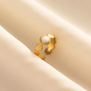 Detailed macro view of a gold vintage ring with white enamel inlay on beige silk