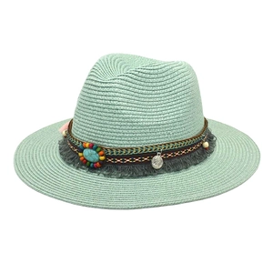 Detail of mint green straw jazz hat with bohemian beads and coin pendant decoration