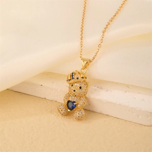 Close-up of gold bear pendant with white micro-pave crystals and blue heart gemstone
