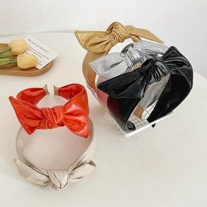 Wide metallic faux leather bow headbands in gold, silver, red, and black finishes