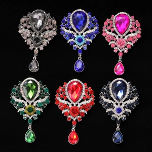 Detail showing crystal teardrop brooches in six colors on a black velvet background