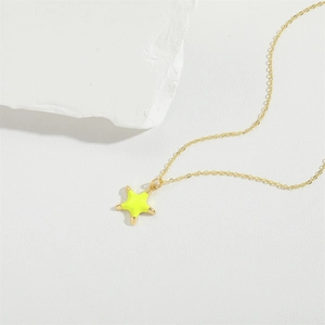 Exquisite gold necklace with a vibrant neon yellow starfish pendant on a white stone