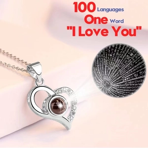 Macro detail of silver heart necklace projecting I Love You in 100 different languages