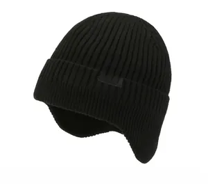 Detail view of black knit ear-flap hat with white SPORT label and ribbed texture