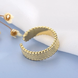 Detail of gold titanium steel open ring with multi-layer groove and gear-like edges