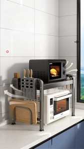 Close-up of a double-layer black metal microwave rack with side storage for kitchen tools
