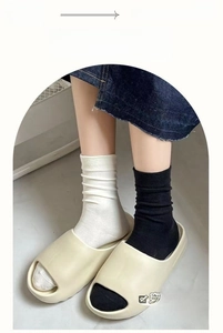 Detailed knit texture of white and black knee-high cotton socks with vertical stripes