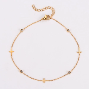 Detail of gold stainless steel anklet featuring cross charms and sparkling zircon stones