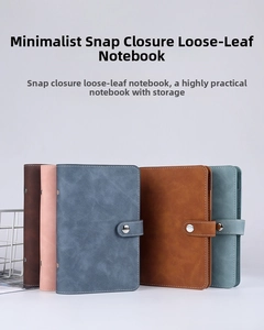 Detail of multi-color loose-leaf binders with matte faux leather texture and buckle