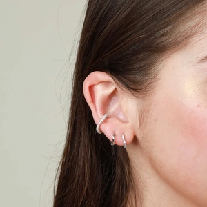 Elegant S925 silver curved hoop earrings with zircon stones worn on model's ear