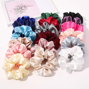 Flat lay of satin silk scrunchies in various vibrant colors with elegant pearl luster finish