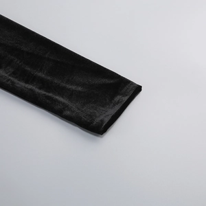 Detail of premium black velvet fabric showing soft texture and subtle sheen on a sleeve