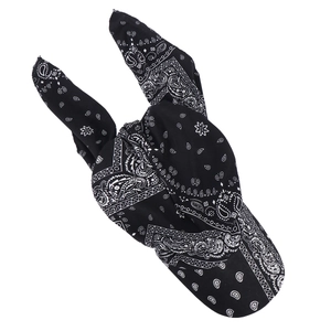 Detail of a black paisley bandana headwrap tied in a decorative rabbit ear bow knot
