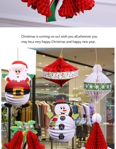 Dettaglio di ornamenti natalizi in carta a nido d'ape con motivi di Babbo Natale e pupazzo di neve