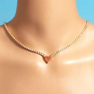 Detail of gold tennis chain necklace with pink heart zircon pendant on mannequin