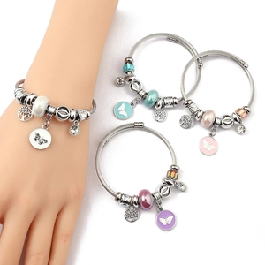 Detailed close-up of beaded stainless steel bracelets with life tree and butterfly charms