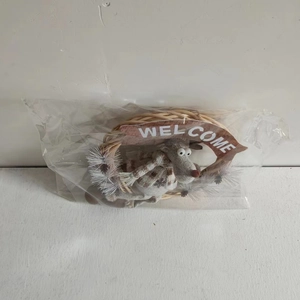 Detail of reindeer plush wreath decoration in plastic packaging with Welcome sign