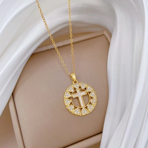 Luxurious gold stainless steel heart cross necklace with crystals on silk background