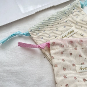 Detail of corduroy floral makeup bag fabric texture and drawstring closure system