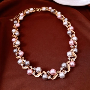 Detailed view of French vintage necklace with pink and white pearls and crystal leaf accents
