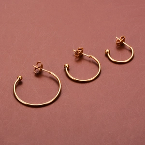 Three-piece set of gold C-shaped stud earrings in small, medium, and large sizes