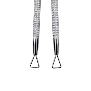 Detailed macro view of professional stainless steel cuticle pusher and trimmer tools