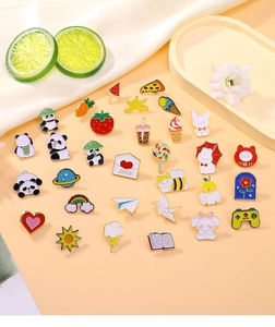 Detailed flat lay of cute cartoon enamel pins featuring pandas, food, and animals on a beige surface