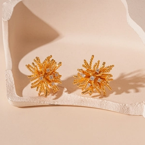 Vue détaillée des boucles d'oreilles feu d'artifice dorées avec cristaux de zircon