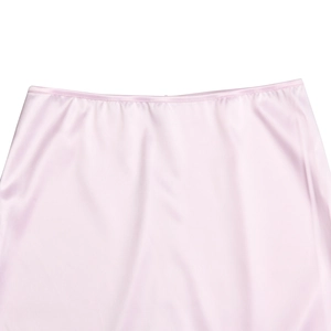 Dettaglio ravvicinato del tessuto in raso rosa liscio e delle cuciture in vita della gonna