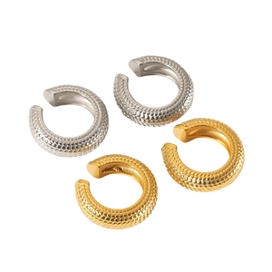 Golden and silver stainless steel ear cuffs with textured snake scale patterns on white background