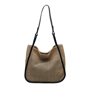 Minimalist straw tote bag with black PU trim and thin shoulder straps on white background