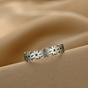 Minimalist stainless steel daisy ring for women on champagne silk background