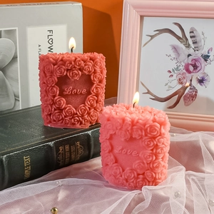 Detailed texture of burning rose heart candle with Love engraving and floral pattern