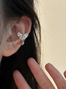 Detailed macro shot of an 18k gold plated zircon heart ear clip with a cross motif