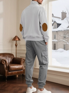 Ensemble matelassé homme avec haut zippé et pantalon texturé dans un décor hivernal intérieur