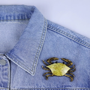 Fashionable acrylic swimming crab brooch with marble texture on blue denim jacket