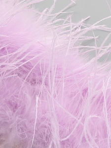 Macro shot of delicate lavender ostrich feathers on a luxury sequined evening dress
