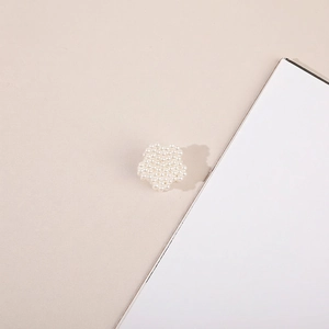 Detail shot of a small five-petal flower hair claw clip with miniature white pearls