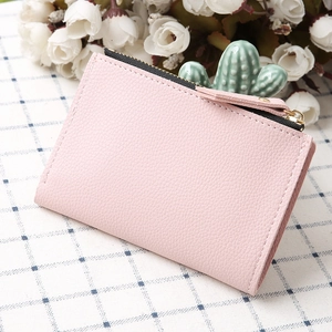 Detail view of pink lychee grain leather wallet with golden zipper and puller