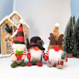 Three Christmas gnomes with plaid hats and reindeer antlers in a festive wooden setting