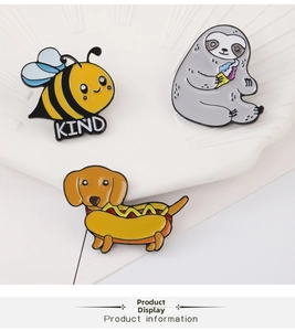 Macro shot of sloth, dachshund, and bee enamel pins on a decorative ceramic dish