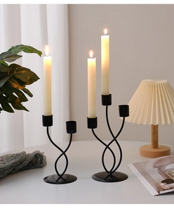 Close-up of minimalist black iron candle holders with elegant curved lines and matte finish