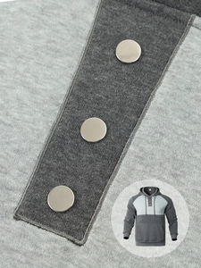 Detail of hoodie neckline with three metal buttons and grey patchwork fabric