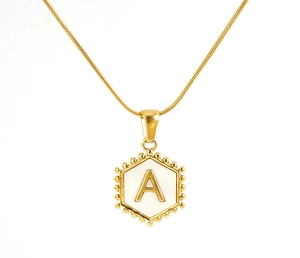Detailed close-up of a gold hexagonal pendant with white shell inlay and letter A engraving