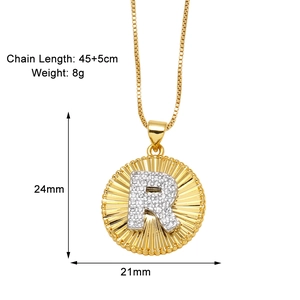 Detail of gold letter R pendant with sunray texture and sparkling rhinestones