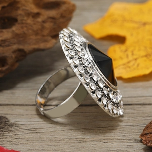 Detail of vintage silver ring with large black gemstone and white rhinestones on wood