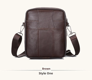 Detailed macro view of dark brown pebbled leather texture on a men's messenger bag