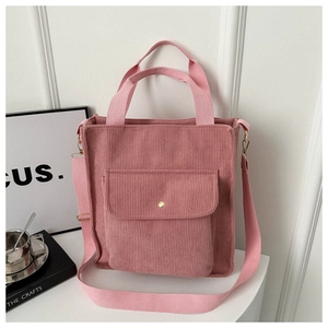 Pink corduroy tote bag showing metal snap button on front pocket and soft texture