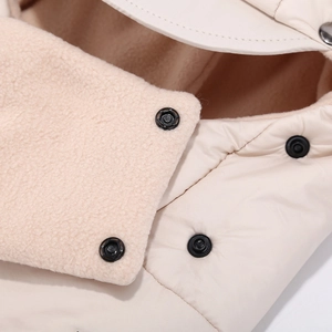 Dettaglio della fodera del cappello invernale con pile rosa e bottoni a pressione neri