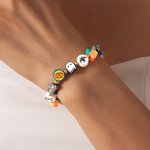 Detail of Halloween beaded bracelet featuring clay pumpkin, ghost and bat charms on wrist